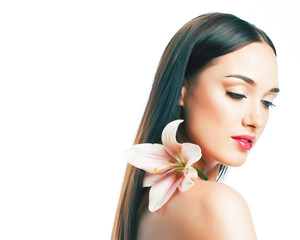 Fototapeta premium young attractive lady close up with hands on face isolated flower lily brunette spa nude makeup, beauty concept
