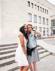 Two teenage diverse nations girls infront of university building smiling, having fun traveling europe, lifestyle people concept