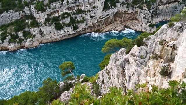 Stunning high angle view of famous narrow bay Calanque d'En-Vau in Calanques National Park near Cassis at the French Riviera with rough sea surrounded by steep cliffs.