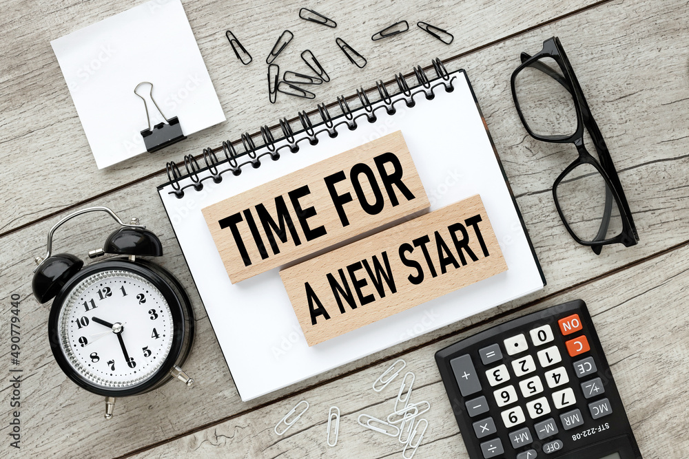 Poster text on wooden blocks on a notepad. business concept. time for a new start