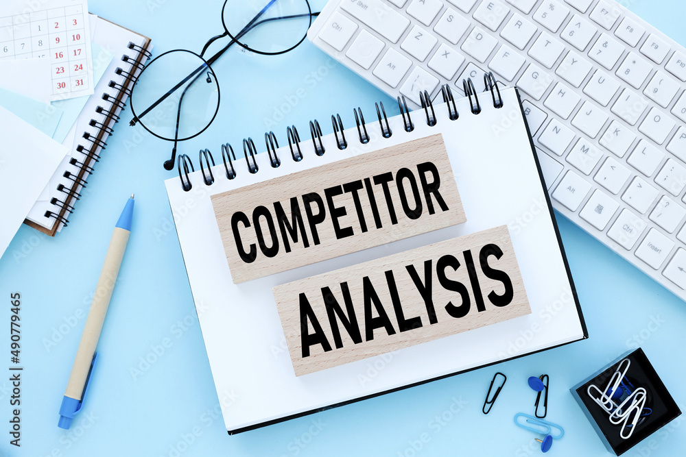 Aufkleber competitor analysis. open notepad on a blue background. text on notepad