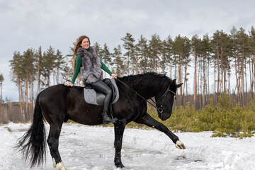 Girl with red hair riding a horse. Winter walk with your beloved pet