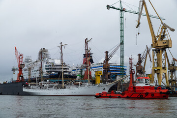 A three-masted sailing ship under repair in a shipyard 