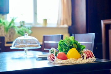 Fresh vegetables in a mesh eco bag on the table in the kitchen