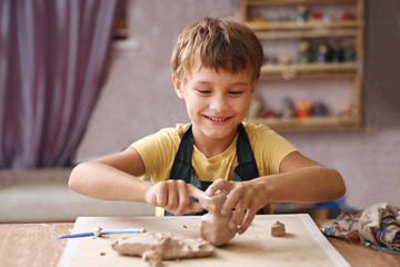 Kid sculpts clay crafts pottery school. hobby. a child with creativity. - obrazy, fototapety, plakaty