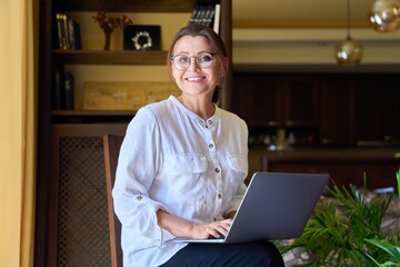 Portrait of smiling middle aged business woman looking at camera.