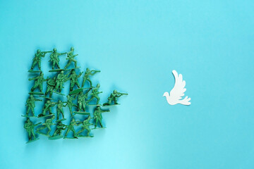 Toy soldiers and dove on blue background. Dove symbol of peace. Pray for Ukraine, No War. close up....