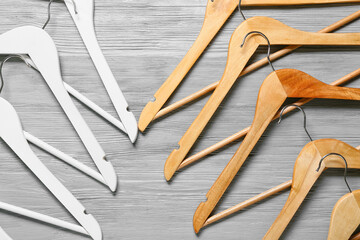 Different clothes hangers on wooden background