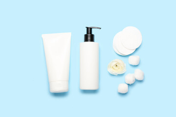Composition with cosmetic products, cotton balls, pads and ranunculus flower on color background