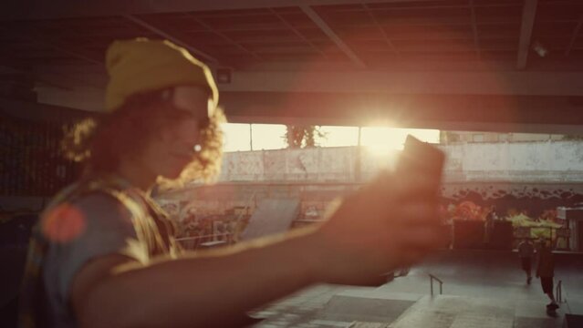 Teenager posing mobile phone camera at skate park. Man taking selfie photo.