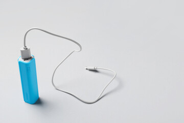 Blue power bank with USB cable on light background
