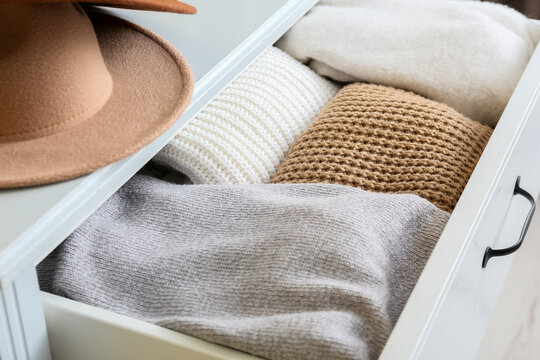 Drawer with warm clothes in room, closeup