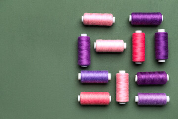 Different sewing threads on green background