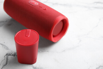 Wireless portable speakers on light background, closeup