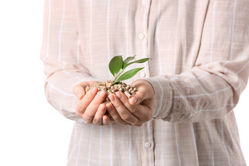 Woman holding pile of wood pellets on white background