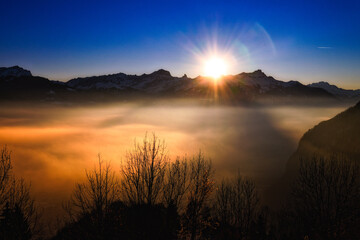 Sunset over a misty landscape in Swiss Alps, Switzerland