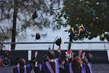 Closeup shot of the students throwing their mortarboards in the air during graduation ceremony