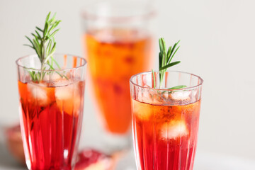 Glasses of tasty pomegranate cocktail on white background, closeup