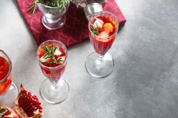 Glasses of tasty pomegranate cocktail on grunge background