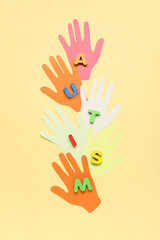 Paper human palms with word AUTISM on beige background