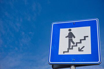 underpass sign for pedestrians and blue sky