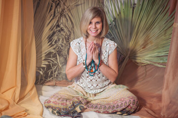 Fototapeta premium The concept of zen, peace, balance. A woman sits and meditates using Mudra, keeping her legs crossed