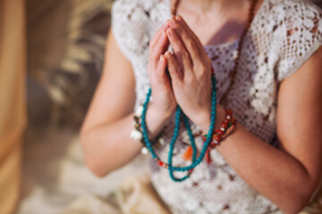 Woman at meditate place in lotus position using Mudra,  hand close up, strands of  beads used for...