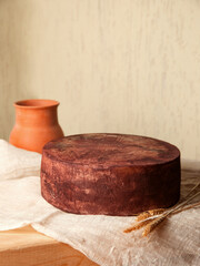cheese of different varieties on a natural wooden background, whole and cut