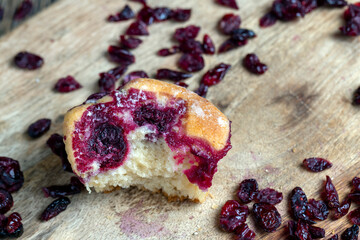 wheat pastries with red cherry strawberry filling on a board, dried cranberries dried in sweet syrup are lying around the baking