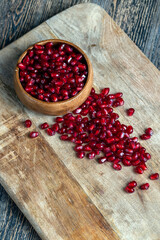 scattered pomegranate seeds on a wooden board