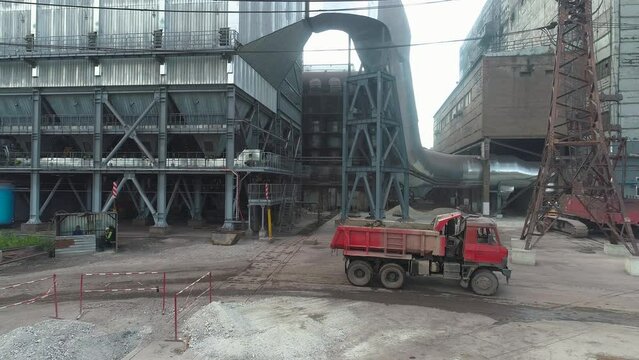Work processes on the territory of a large factory. Industrial exterior. The truck drives through the factory