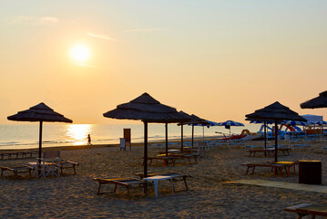 Fototapeta na wymiar Umbrellas and sunbeds on the beach of Rimini in Italy