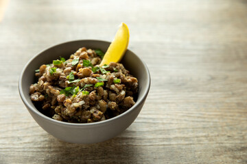 Lentil salad with homemade mustard and lemon juice wedge. Ethiopian cuisine. Azifa dish with senafich spice.