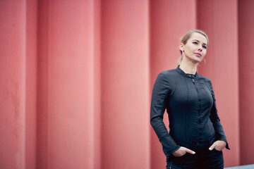 portrait of a blonde woman in a black denim catsuit