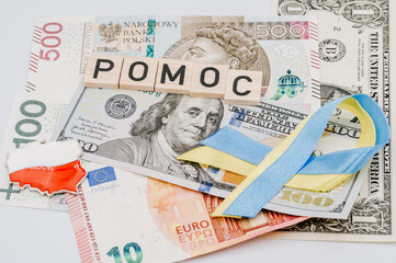 Napis pomoc i wstążka w barwach Ukrainy na tle banknotów - obrazy, fototapety, plakaty
