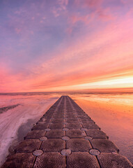 Vertical shot of the empty stone tiled footpath against the beautiful sunset.