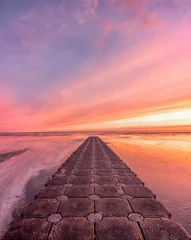 Foto auf Acrylglas Hell-pink Vertikaler Schuss des leeren Steinfußweges gegen den schönen Sonnenuntergang.