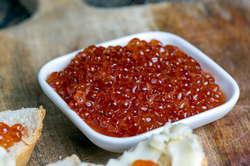 red salmon or trout caviar with white baguette and butter