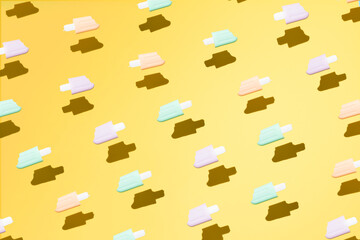 Pink, turqois ice creams flying on yellow background. Minimal summer background