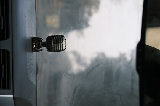 Mic Air Freshener Bobblehead On A Car Dashboard