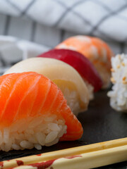 close-up of three pieces of sushi, dark background 