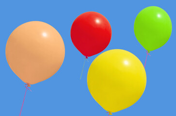 Multicolored balloons fly against the blue sky