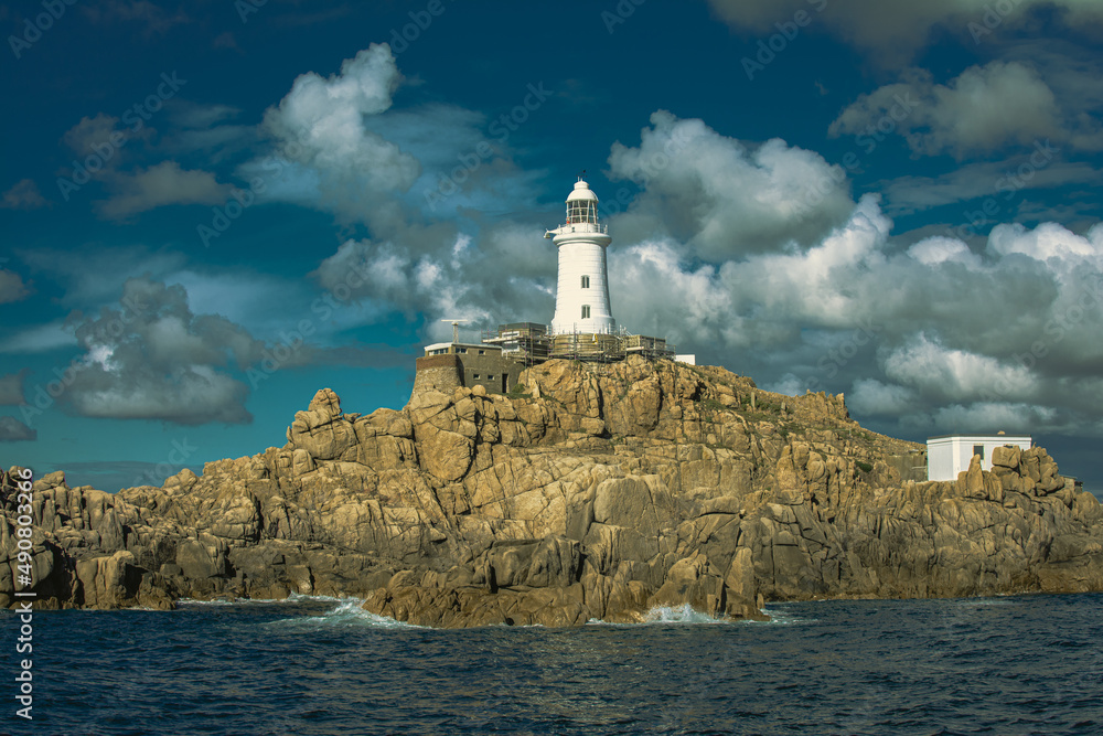 Poster scenic view of a white lighthouse on a cloudy sky background
