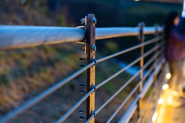 Selective focus shot of wire railings with fairy lights at a park