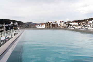 Panoramic view at the pool in the mountain over a landscape with low hanging clouds in skiing resort