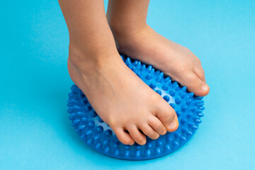 children's feet with a blue balancer on a light blue background, treatment and prevention of flat...