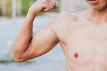 A young man shows off his muscles.
