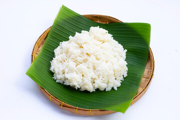 Sticky rice on banana leaf in bamboo basket on white background.