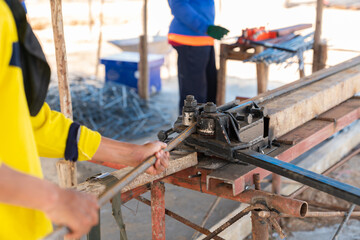 The worker is bending rebars steel rods.