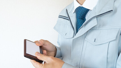 作業服にネクタイの男性｜建設業・名刺、ビジネスカードの交換